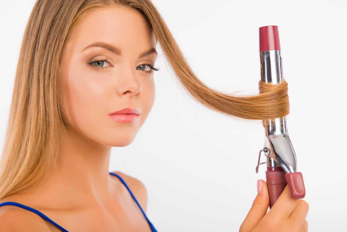 woman curling hair with curling iron