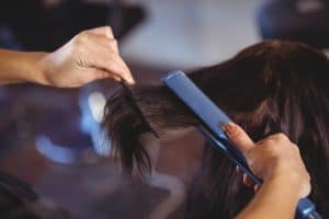 straightening hair with blue flat iron