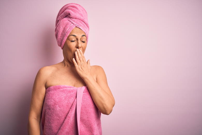 woman in pink towel yawning